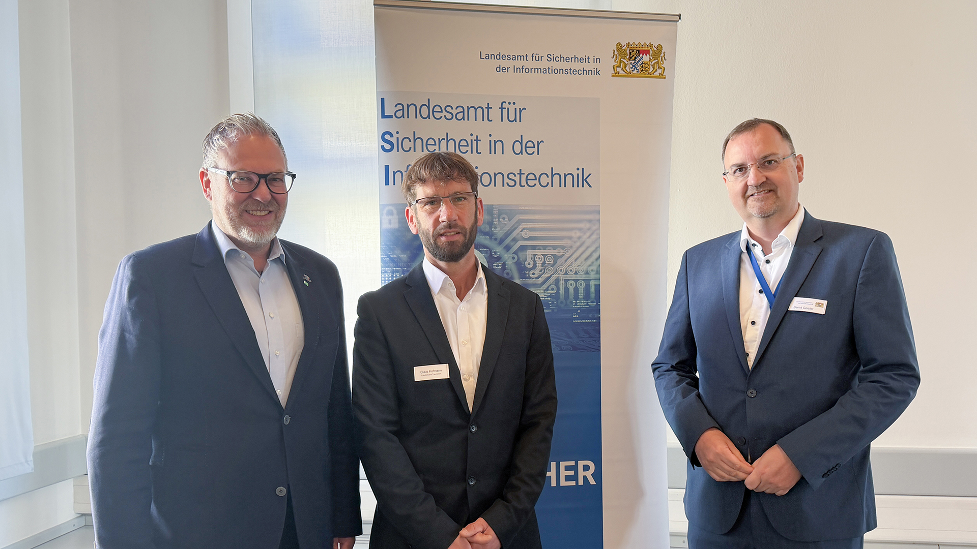 Beim LSI-Thementag „Kommunale IT-Sicherheit“ im Landratsamt Traunstein (von links): Landrat Andreas Danzer, Claus Hofmann, Informationssicherheitsbeauftragter und CISO des Landratsamts Traunstein, sowie Bernd Geisler, Präsident des Landesamts für Sicherheit in der Informationstechnik in Bayern (LSI), vor dem LSI-Banner.