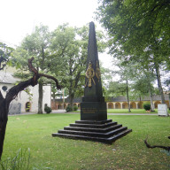 Traunstein, Stadtpark: Obelisk zur Erinnerung an die Gefallenen der Napoleonischen Kriege vor der Kirche St. Georg und Katharina ©Landratsamt Traunstein