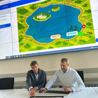 Claus Hofmann (Informationssicherheitsbeauftragter, links) und Andreas Klimm (Projektmanagement Office, rechts) präsentieren das neue Lernspiel „Radltour um den Chiemsee“ zur Cybersicherheit. ©Landratsamt Traunstein