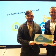 © Landratsamt Traunstein: Robert Ossenkopp (links), Mobilreferent des Projekts „Digitale Nachbarschaft“, überreicht Freiwilligenagenturleiter Florian Seestaller die offizielle DiNa-Treff-Plakette.