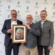 Bildunterschrift:  Landrat Andreas Danzer (li.) bedankt sich gemeinsam mit Florian Seestaller, Leiter der Bürgerhilfsstelle im Landratsamt Traunstein (re.), bei Peter Schimpf, Vorstand der Georg Johannes Hipp-Stiftung (Mi.), für die großzügige Spende in Höhe von 20.000 Euro. Das Foto zeigt die drei bei der Spendenübergabe im Landratsamt Traunstein – mit einem Porträt des Stifters Georg Johannes Hipp, dessen Engagement für Menschen in Not fortgeführt wird.  ©Landratsamt Traunstein